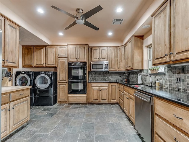 kitchen with visible vents, separate washer and dryer, a sink, appliances with stainless steel finishes, and dark countertops