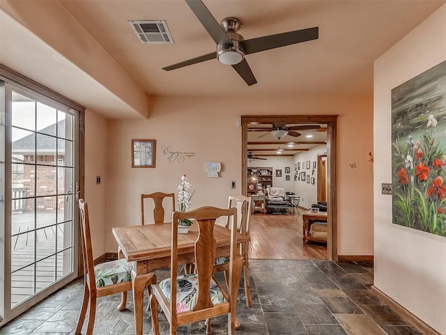 dining space featuring visible vents, baseboards, and stone finish floor