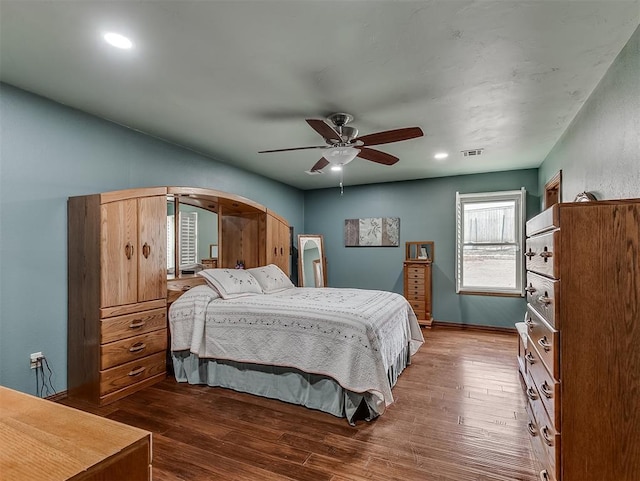 bedroom featuring visible vents, wood finished floors, arched walkways, baseboards, and ceiling fan