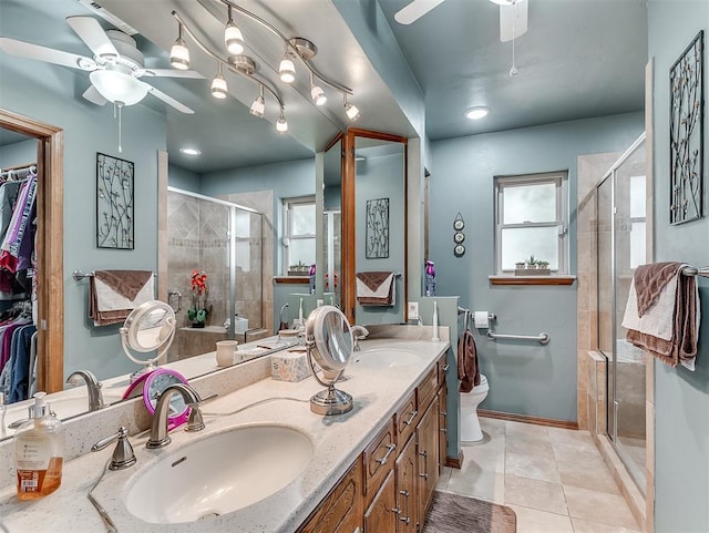 full bathroom with double vanity, a stall shower, ceiling fan, and a sink