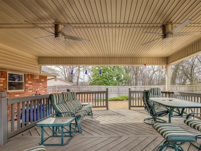 wooden deck with ceiling fan and a fenced backyard