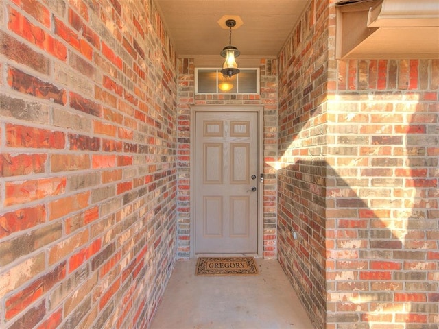 view of exterior entry with brick siding