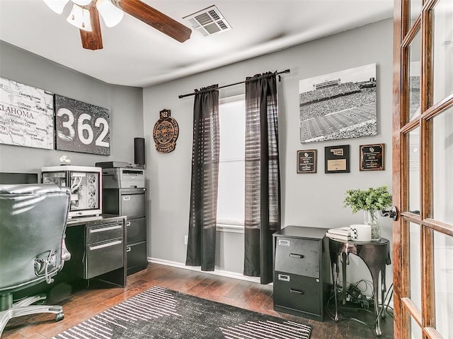 office featuring visible vents, baseboards, dark wood finished floors, and a ceiling fan