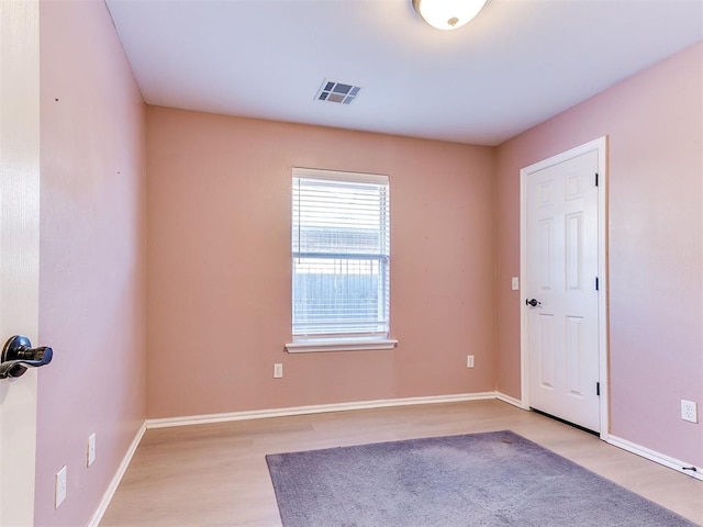 empty room with visible vents, baseboards, and light wood-style floors