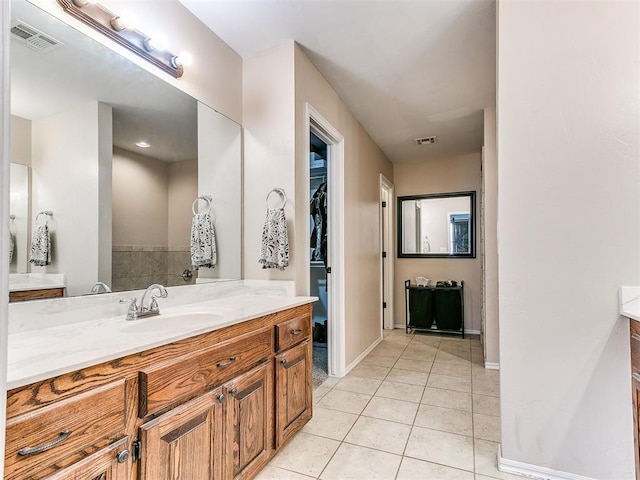 full bathroom featuring tile patterned floors, visible vents, a spacious closet, and vanity