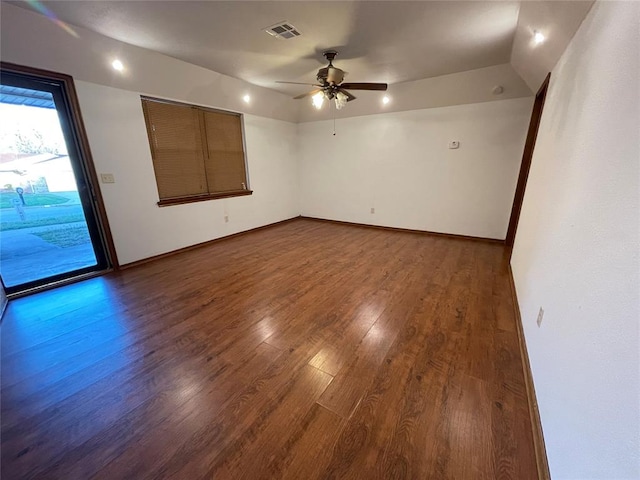 empty room with dark wood-type flooring, baseboards, visible vents, and ceiling fan