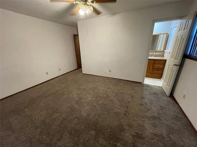 unfurnished bedroom with light colored carpet, a ceiling fan, connected bathroom, and a sink