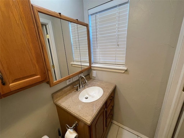 bathroom with vanity, tile patterned floors, and baseboards