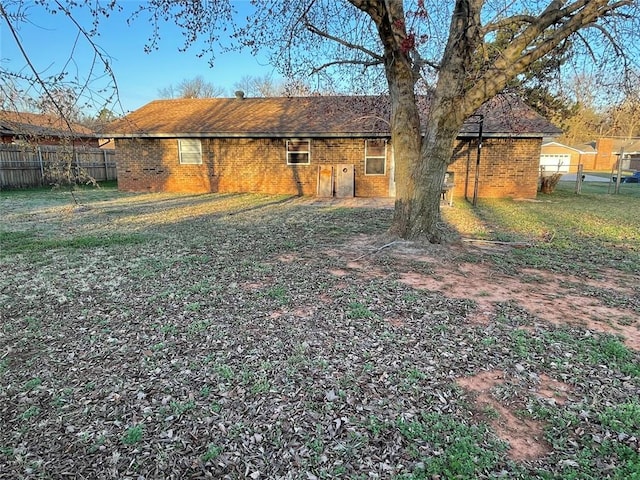 rear view of property with brick siding and fence