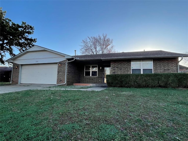 single story home featuring brick siding, an attached garage, concrete driveway, and a front lawn