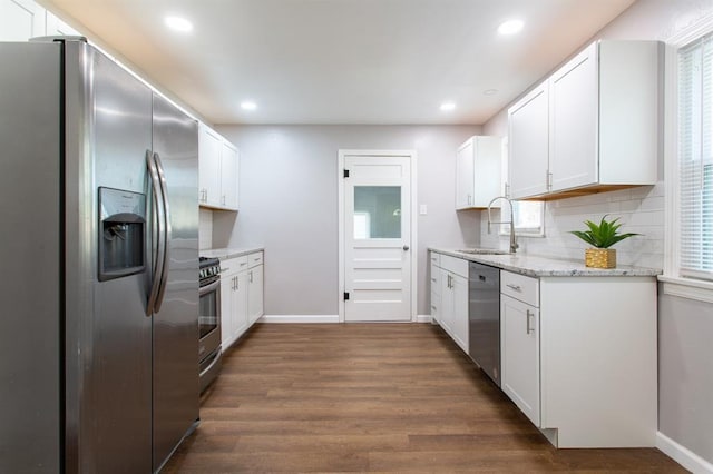 kitchen featuring dark wood-style floors, baseboards, stainless steel appliances, decorative backsplash, and white cabinets