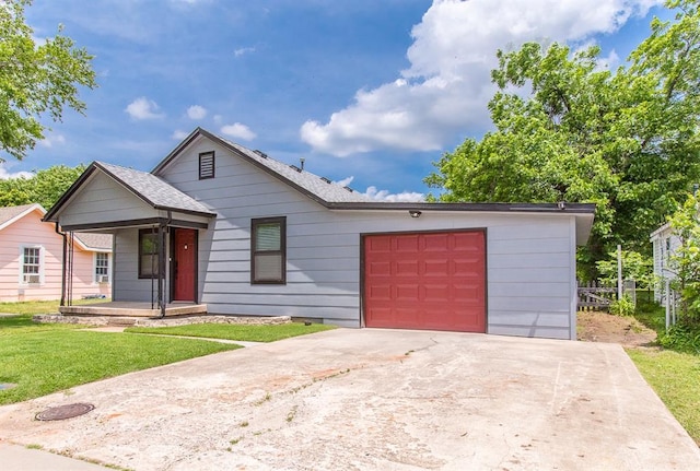 view of front facade with an attached garage, a shingled roof, driveway, and a front lawn