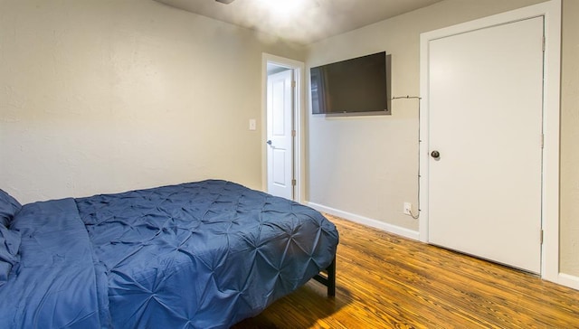 bedroom with wood finished floors and baseboards