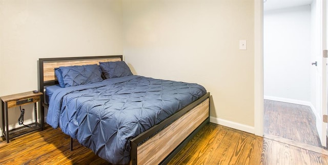 bedroom with baseboards and wood finished floors