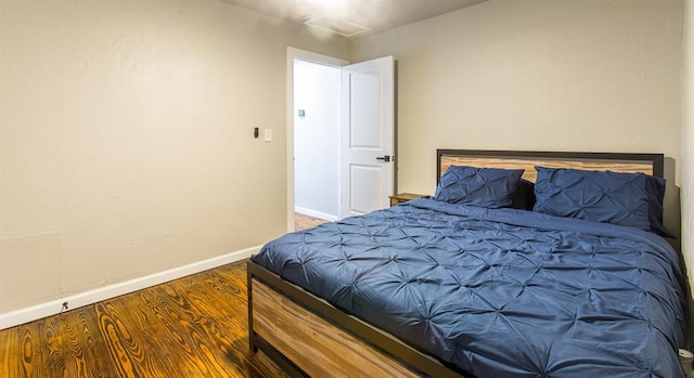 bedroom with baseboards and wood finished floors