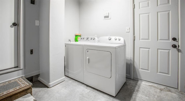 washroom with laundry area, washing machine and dryer, and baseboards