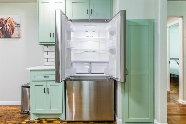 kitchen featuring stainless steel refrigerator, tasteful backsplash, wood finished floors, green cabinets, and baseboards