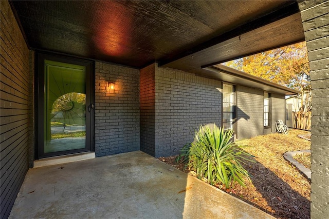 entrance to property featuring brick siding