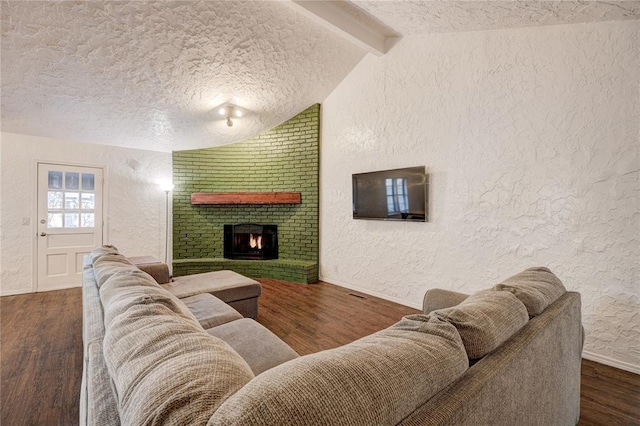 living room featuring wood finished floors, vaulted ceiling with beams, and a textured wall