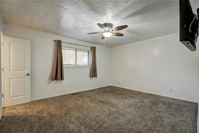 spare room with a ceiling fan, a textured wall, carpet floors, and a textured ceiling