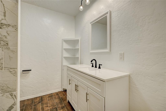 bathroom with vanity, wood tiled floor, and a textured wall