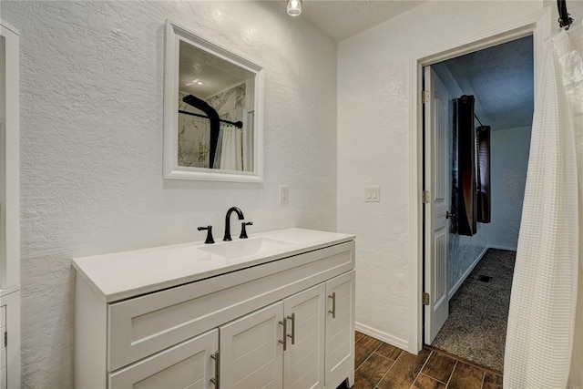 bathroom with vanity, a shower with curtain, a textured wall, and wood tiled floor