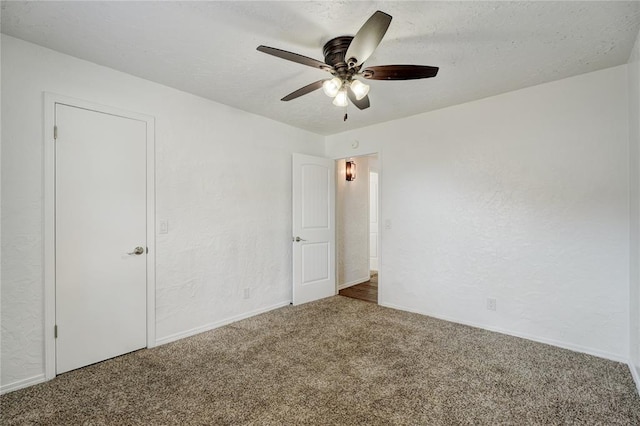 unfurnished bedroom with carpet flooring, ceiling fan, and a textured wall