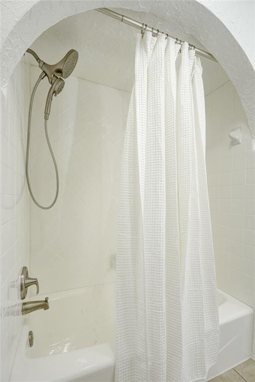 full bath featuring shower / tub combo and tile patterned flooring