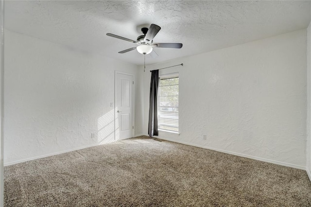 carpeted spare room featuring a textured ceiling, a textured wall, and ceiling fan