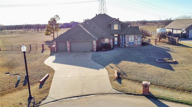 view of front of house featuring brick siding, an attached garage, fence, roof with shingles, and driveway