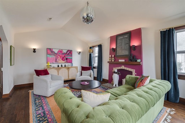 living area with baseboards, lofted ceiling, wood finished floors, and a fireplace