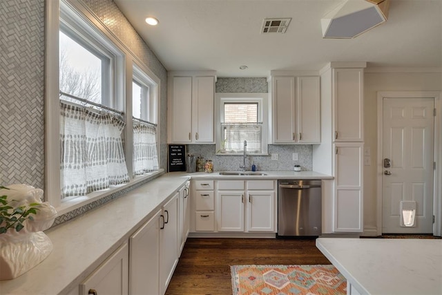 kitchen with visible vents, dishwasher, light countertops, white cabinets, and a sink