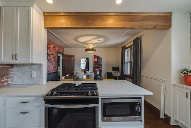 kitchen with white cabinetry, a peninsula, beamed ceiling, and appliances with stainless steel finishes