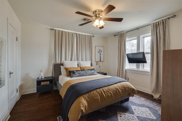 bedroom with ceiling fan, visible vents, baseboards, and wood finished floors