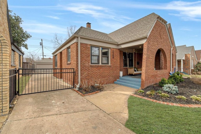 view of front of property with brick siding, a shingled roof, fence, a chimney, and a gate