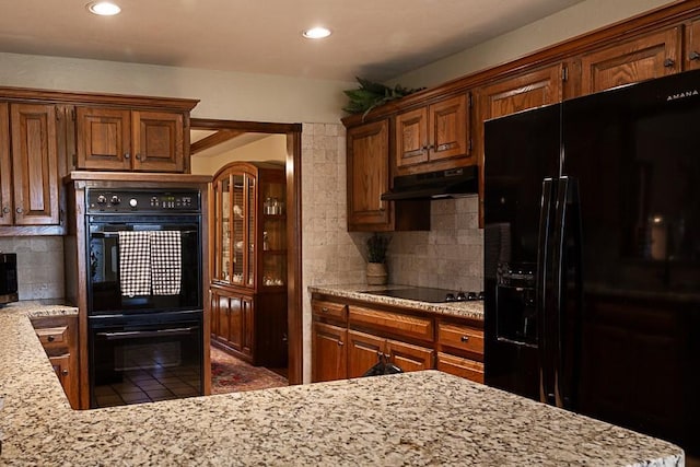 kitchen with tile patterned flooring, black appliances, tasteful backsplash, and under cabinet range hood