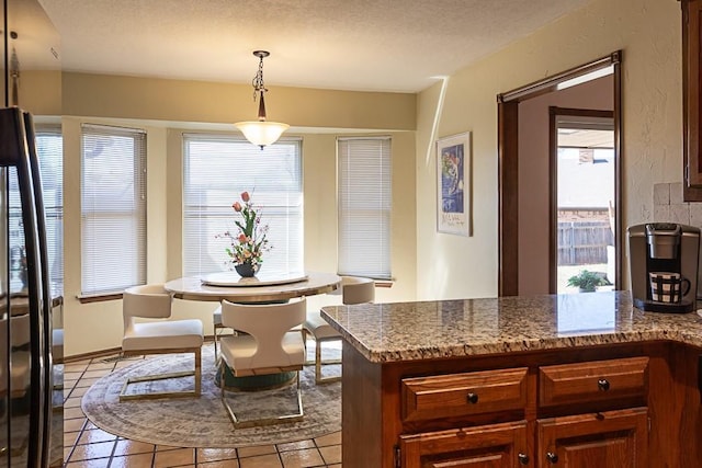 dining area featuring light tile patterned flooring and a textured ceiling