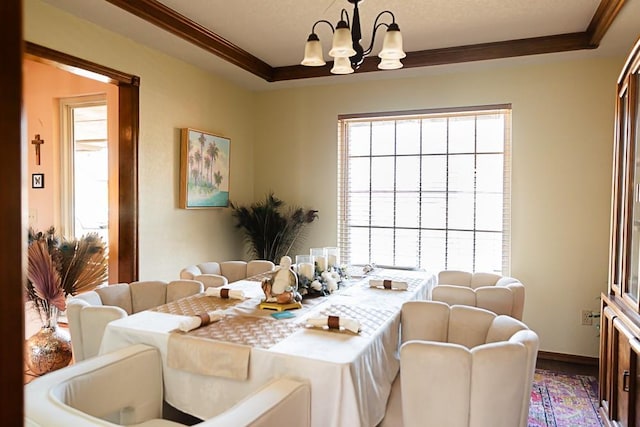 dining space with a chandelier, a healthy amount of sunlight, and ornamental molding