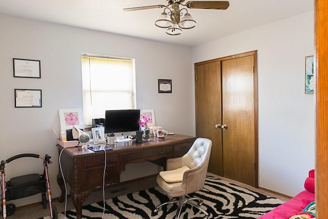 office area with a ceiling fan and baseboards