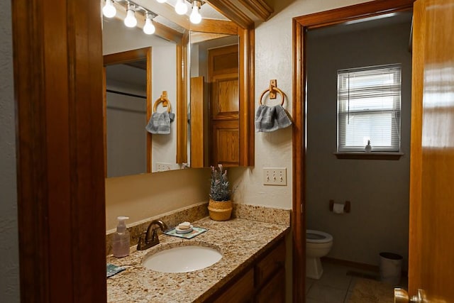 bathroom featuring vanity, tile patterned floors, and toilet