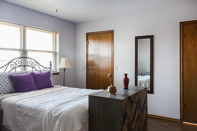 bedroom featuring baseboards and dark wood-type flooring