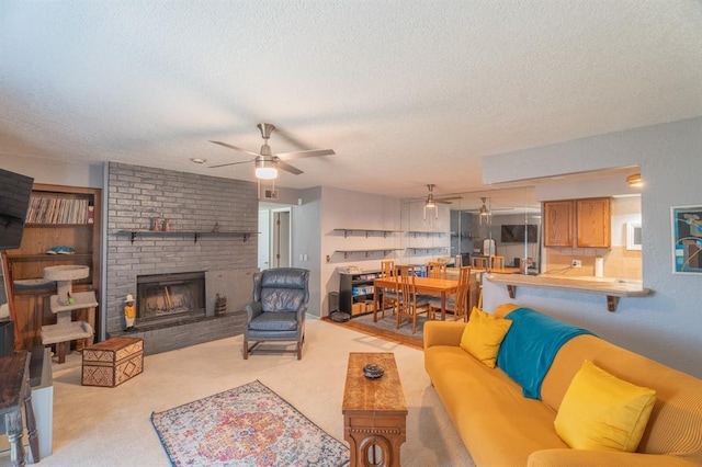 living room featuring a brick fireplace, a textured ceiling, a ceiling fan, and carpet floors