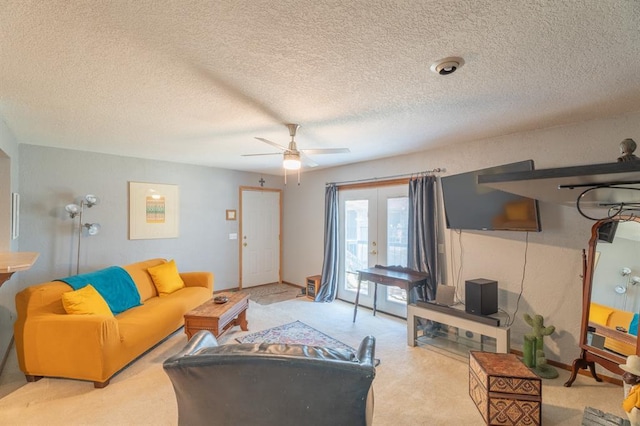 carpeted living area featuring french doors, a textured ceiling, and ceiling fan