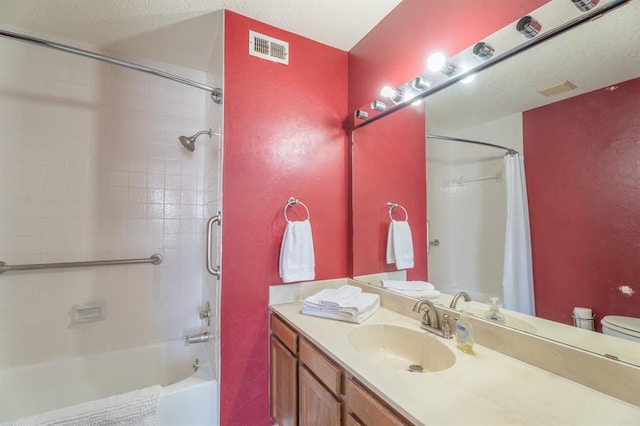 bathroom with vanity, shower / bathtub combination with curtain, visible vents, toilet, and a textured wall