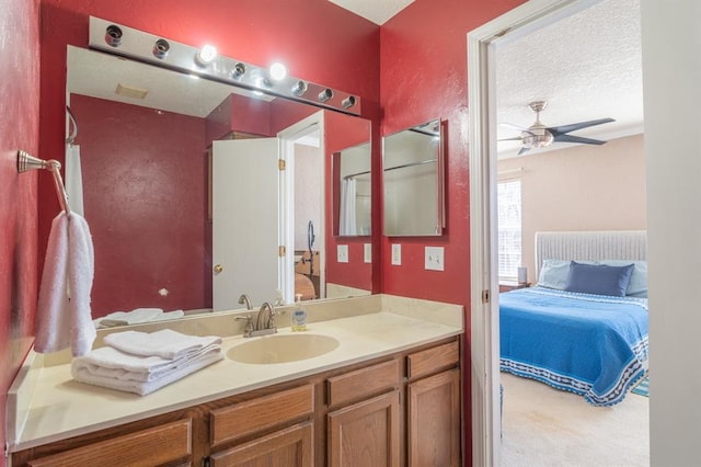 ensuite bathroom with vanity, ceiling fan, ensuite bathroom, and a textured ceiling