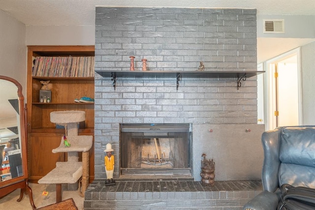 details with visible vents, a textured ceiling, and a brick fireplace