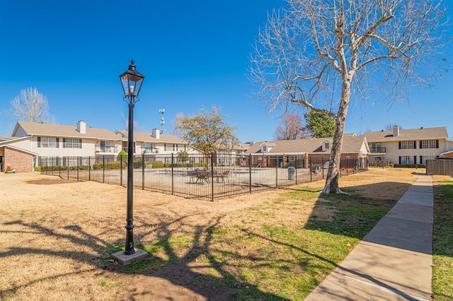 surrounding community featuring a yard, fence, and a residential view