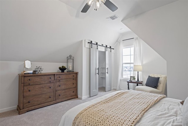 carpeted bedroom with visible vents, baseboards, a barn door, lofted ceiling, and ceiling fan