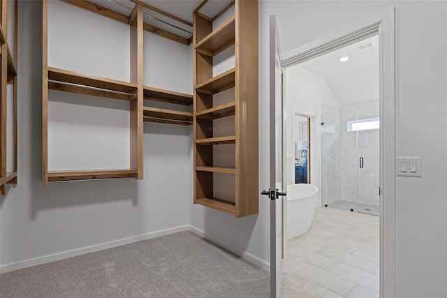 spacious closet with carpet and vaulted ceiling