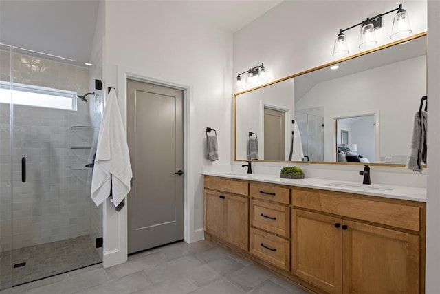 full bathroom with double vanity, a shower stall, and a sink